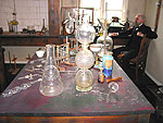 Interir frn Alfred Nobels laboratorium. Lngst bort till hger ses Alfred sjlv sitta och fundera.